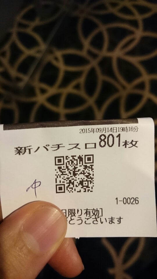 「新パチスロ801枚」と印字された交換レシートを手に持つ様子