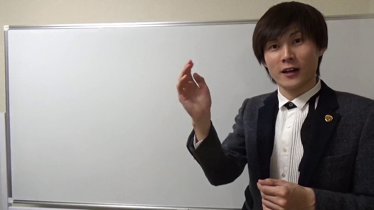 ホワイトボード前でスーツ姿の本人が片手を挙げて解説する(結果を出している人から学ぶ)