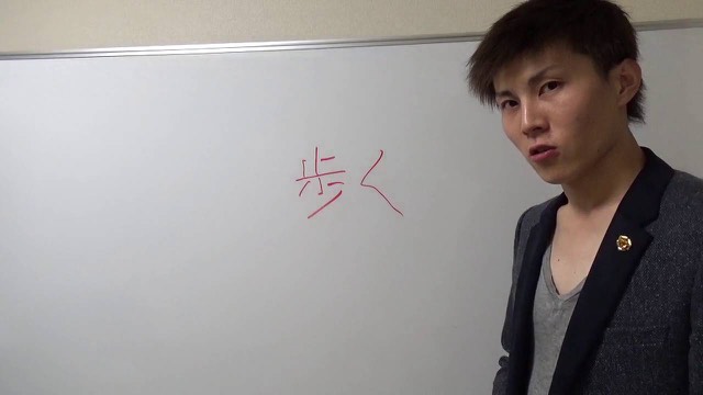 ホワイトボードに赤字で「歩く」と書かれ、振り返る本人の横顔(動画「勝ちたいなら、まずは早歩き【パチスロ】【スロット】」より)