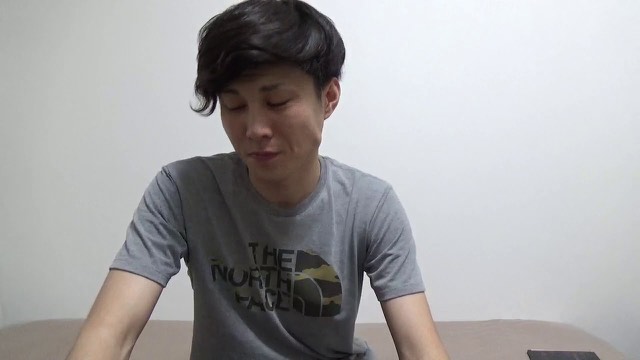 無地の壁を背景にグレーのノースフェイスTシャツ姿の本人がうつむき気味に話す(動画「これから稼げる仕事は何か?」より)