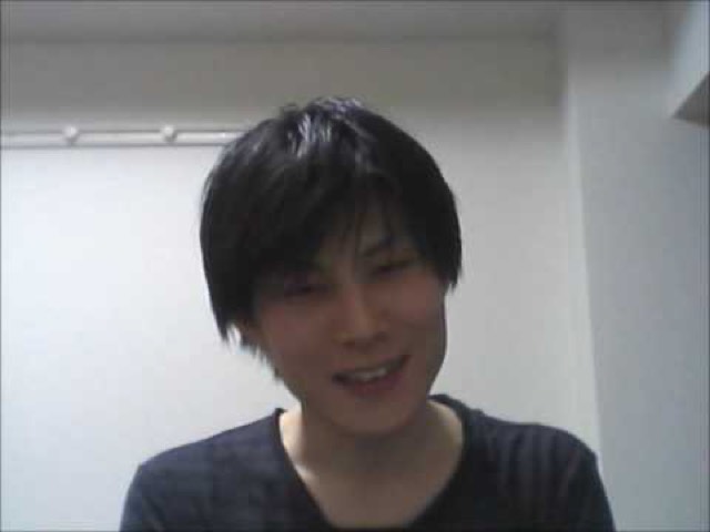 縞シャツで正面を見る本人の顔アップ(動画「ダサい人ほどパチスロは損をする」より)