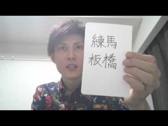 「練馬 板橋」と書かれた紙を掲げる本人(練馬)(動画「10月稼働地域の抽選」より)
