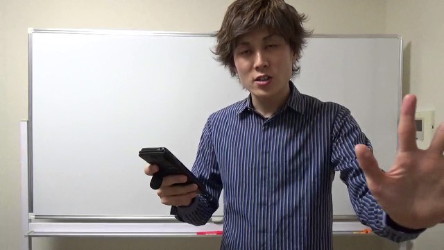 スマホを持ちホワイトボード前に立つ本人(動画「パチスロ業界で最強になれる考え方【パチスロ】…」より)